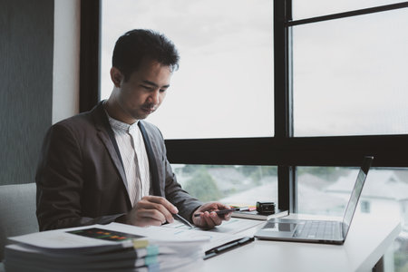 he is using his phone to find information to use in presenting information, Entrepreneurs use smartphones to keep in touch with business partners while working in the company, startup idea.の写真素材