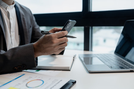 he is using his phone to find information to use in presenting information, Entrepreneurs use smartphones to keep in touch with business partners while working in the company, startup idea.の写真素材