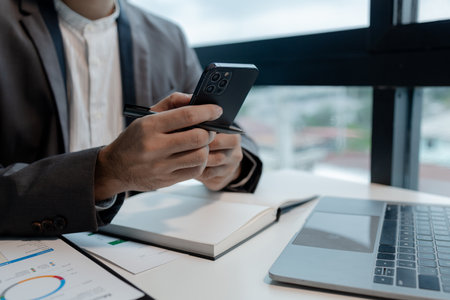he is using his phone to find information to use in presenting information, Entrepreneurs use smartphones to keep in touch with business partners while working in the company, startup idea.の写真素材