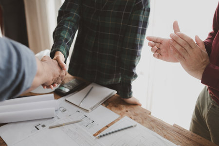 The architect shake hands with the foreman as the job was agreed upon, An engineer contracts with a company to construct a building, Engineer and architect check hand as work is finalized.の写真素材