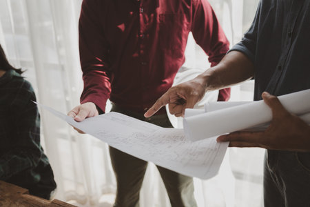 Commercial buildings are being evaluated by architects on what type of construction they need to be built,  Engineers are designing a structure according to blueprints.の写真素材