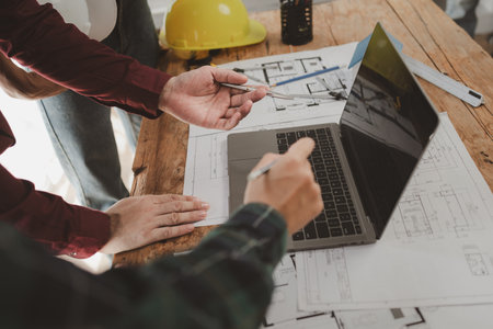 Architects and engineers work together to come up with solutions to house building problems, The property is about to be designed by a group of engineers, Architects are reviewing plans together.の写真素材