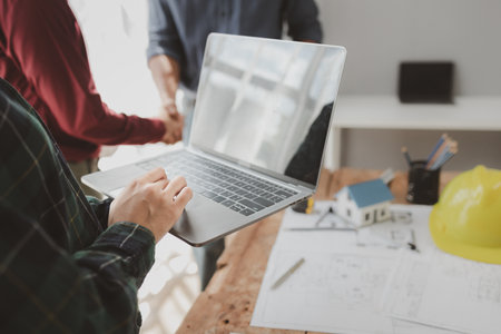 Commercial buildings are being evaluated by architects on what type of construction they need to be built,  Engineers are designing a structure according to blueprints.の写真素材