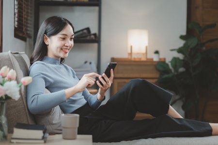 Woman is sitting and relaxing on the sofa, Sitting comfortably on the sofa, Relax in the living room at home on holiday, Live a comfortable life, Sitting on the sofa at the apartment.の写真素材