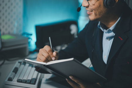 Call center employee talking with customer through headset, The operator is providing customer service by phone, Customer service staff is providing support and helping resolve issues.の写真素材