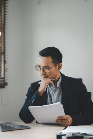 Businessman is stressed because of business problems in the office, worried about the company's problems, Thinking of solving the problem of stress from the loss of the company,の写真素材
