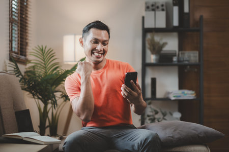 Relax at home on the weekends, Using a smartphone on the sofa at home, Call friends and talk happily, Video call with friends via smartphone, Use your smartphone to do online activities.の写真素材