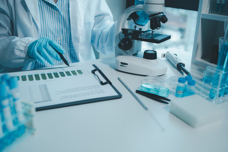 Chemist taking notes on research data, Scientist is working in the laboratory, Chemist is analyzing...