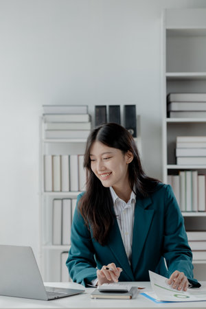 Accountant calculating numbers on calculator, Auditor is working on accounting in the office, Numerical data is being presented for the accountant to calculate,の写真素材