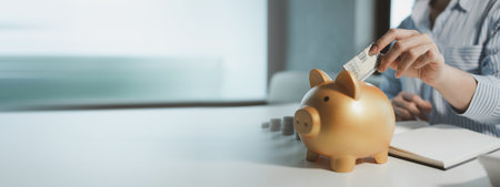 Accountant is putting money into a piggy bank, Financier is bringing savings methods to clients who come to receive advice, Employees are taking customers' savings and keeping them safe.の写真素材