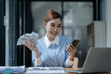 A business owner is counting money and making notes in a financial book, The financier is verifying the income received from the client's investment,の写真素材