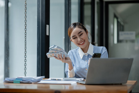 A business owner is counting money and making notes in a financial book, The financier is verifying the income received from the client's investment,の写真素材