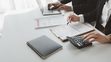 Group of businessmen working together to calculate income, They are revising the financial numbers, Take out financial documents and check them with a calculator,の写真素材