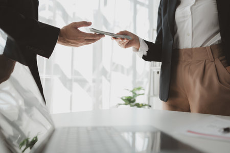 Handing stacks of money to each other in the office, Give money to officials for some business-related reason, Receive kickbacks from corruption in business.の写真素材