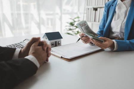 The broker receives the first instalment of the home purchase from the buyer, Counting home instalment payments from customers, Make an appointment to meet with customer at the home sales office.の写真素材