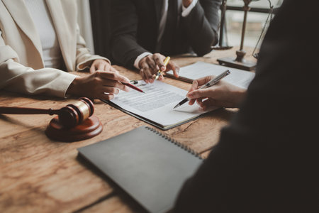 Business people negotiating a contract, discussing contract while working together in sunny modern office, unknown businessman and woman with colleagues or lawyers at meeting.の写真素材
