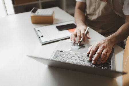 owner of an online store packs products into parcel boxes based on orders from online sales sites, packs products for delivery to addresses via private courier service. Product packaging concept.の写真素材