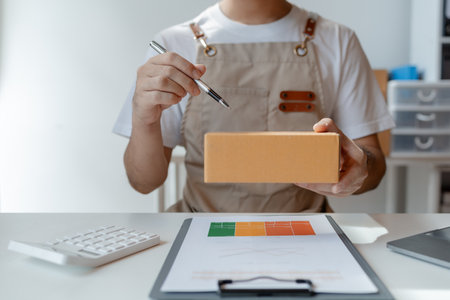 owner of an online store packs products into parcel boxes based on orders from online sales sites, packs products for delivery to addresses via private courier service. Product packaging concept.の写真素材