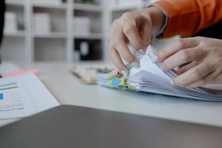 Businesswoman hands working in stacks of paper files for searching, business employee woman working...