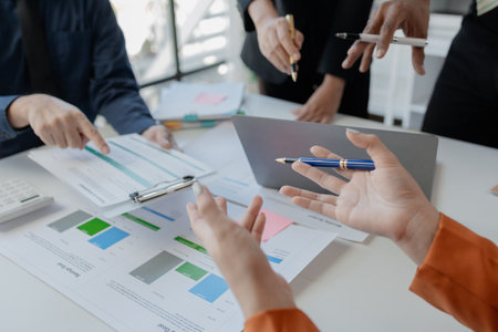 group of employees is discussing the details of an upcoming event, close-up view of the meeting situation, Business men and women are having a tense meeting in a translucent conference room.の写真素材