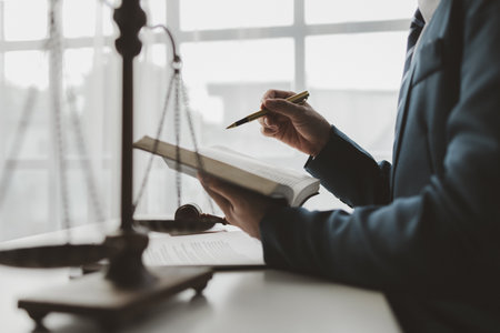 The lawyer sits in his private office, A reliable lawyer is sitting in a firm, The judge is studying information about future cases, concept of justice and law judge in courtroom on wooden table.の写真素材