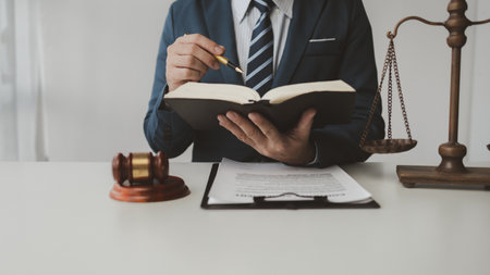 The lawyer sits in his private office, A reliable lawyer is sitting in a firm, The judge is studying information about future cases, concept of justice and law judge in courtroom on wooden table.の写真素材