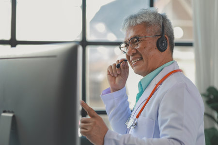 A dignified middle-aged male doctor was sitting in his private office at the hospital, Doctors are sitting and working in various poses. at the hospital happily and happily at workの写真素材