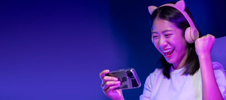 A beautiful Asian gamer is cheering as she wins a game in her private room, I am happy to have won...