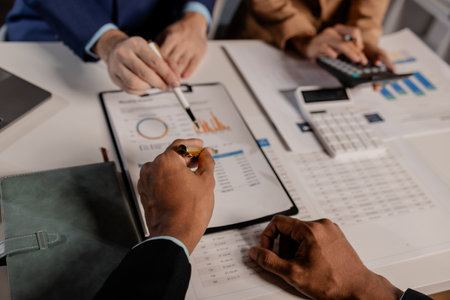 A group of business people are discussing company figures to resolve quarter of the year's losses, A group of employees is meeting to come up with a strategy to increase profits for the company.の写真素材