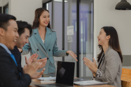 A group of employees is working together on a very important company project that an important customer has hired to work on, Exchange work information with colleaguesの写真素材