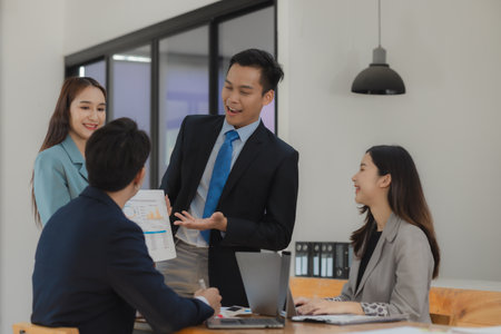 A group of employees is working together on a very important company project that an important customer has hired to work on, Exchange work information with colleaguesの写真素材