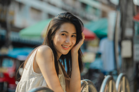 a beautiful Asian woman is walking around street food market in day time, lovely teenager is smiling and feeling happy on her holiday,  traveler gorgeous woman extremely enjoy on her vacationの写真素材