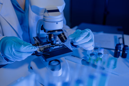 scientist is using microscope in laboratory, chemical researcher works in chemistry with...