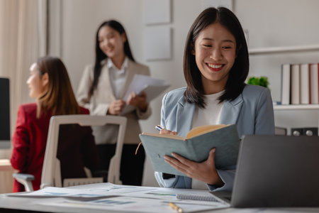 three businessperson are working in the modern office, group of employee has discussion about new project, working as teamwork is more effective, coworkers are brainstorming to planing great strategyの写真素材
