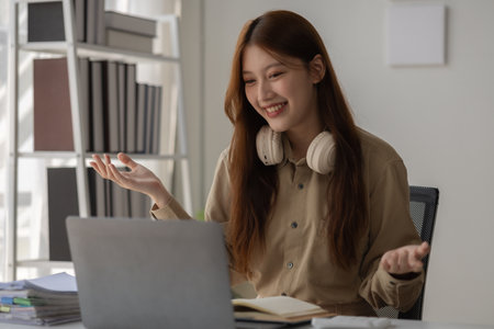 an Asian beautiful businesswoman and her team are discussion via video conference with her client about planing of new strategy, a CEO is meeting with her team via video call in her private office,の写真素材