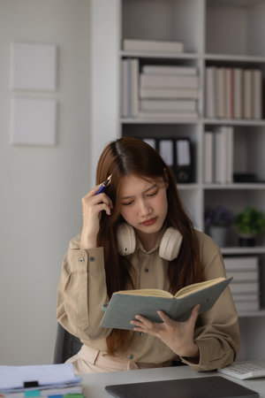 an Asian businesswoman feels tired and confused about her work, an employee worried and upset to her work because her boss doesn't approve it, so many problem and unhappy to workの写真素材