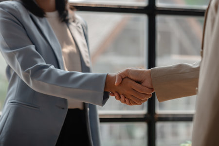 two big companies handshake because they agree on a business deal, businesspeople just signed commitment contract for merge and expand their business for they will get more customer base than normallyの写真素材