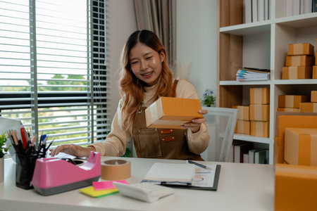 the owner has the checklist with her in the workplace, she is doing well preparation about all of the package before deliver to customers, checking information of customer for accuracyの写真素材