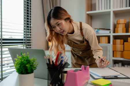 an entrepreneur or a business owner works in her office full of packages, it is a small business that she created with careful preparation, start up business of clothesの写真素材