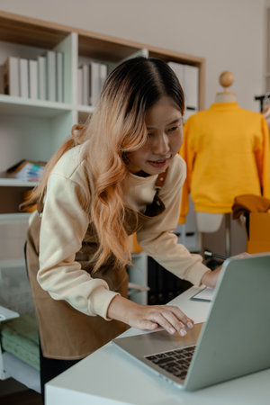 an entrepreneur or a business owner works in her office full of packages, it is a small business that she created with careful preparation, start up business of clothesの写真素材