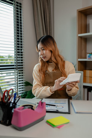 an entrepreneur or a business owner works in her office full of packages, it is a small business that she created with careful preparation, start up business of clothesの写真素材
