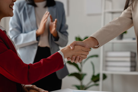 two big companies handshake because they agree on a business deal, businesspeople just signed commitment contract for merge and expand their business for they will get more customer base than normallyの写真素材