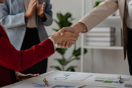 two big companies handshake because they agree on a business deal, businesspeople just signed commitment contract for merge and expand their business for they will get more customer base than normallyの写真素材