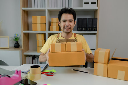 An entrepreneur is checking products in the system and packing them up to ship to buyers from his...