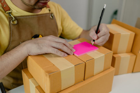 An entrepreneur is working in a warehouse preparing packages for delivery drivers to pick up and deliver to customers, parcel, product, package, startup business, merchandiseの写真素材