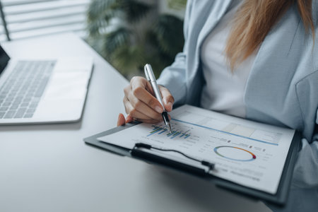 a businesswoman is working in her office at workplace, an employee works at the desk about new project, close up at woman hands, working at her desk in work hours.の写真素材