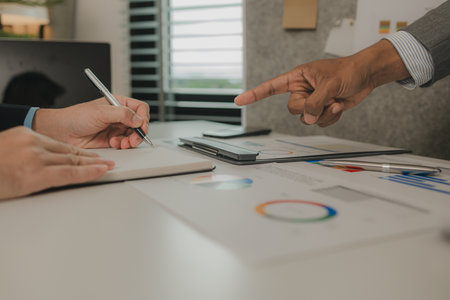 two businessmen are having a meeting and discussing the content of an important paperwork, there is a discussion between the businessman and his business partner, teamwork, workplaceの写真素材