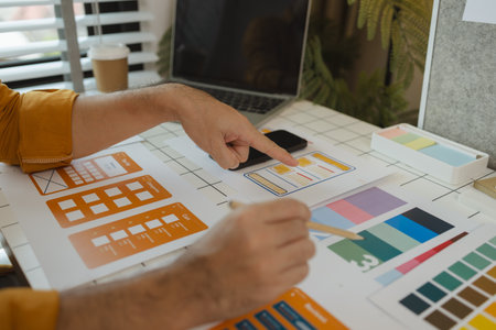 A web designer is using his idea to create a digital product design project that will meet the needs of users in terms of both appearance and feel when using it, ux, ui, interface, experience.の写真素材