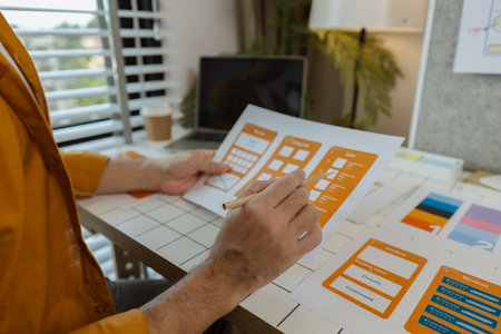 A web developer, as a User Experience and User Interface Officer, is designing beautiful and easy-to-use digital products that create a positive emotional and visual experience for users.の写真素材