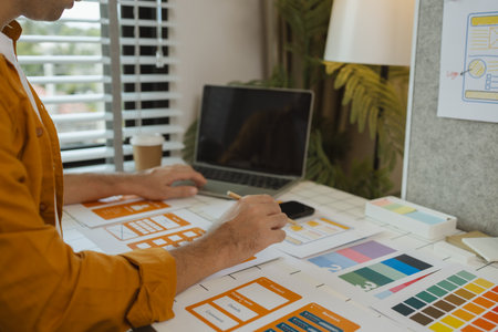 A web designer is using his idea to create a digital product design project that will meet the needs of users in terms of both appearance and feel when using it, ux, ui, interface, experience.の写真素材